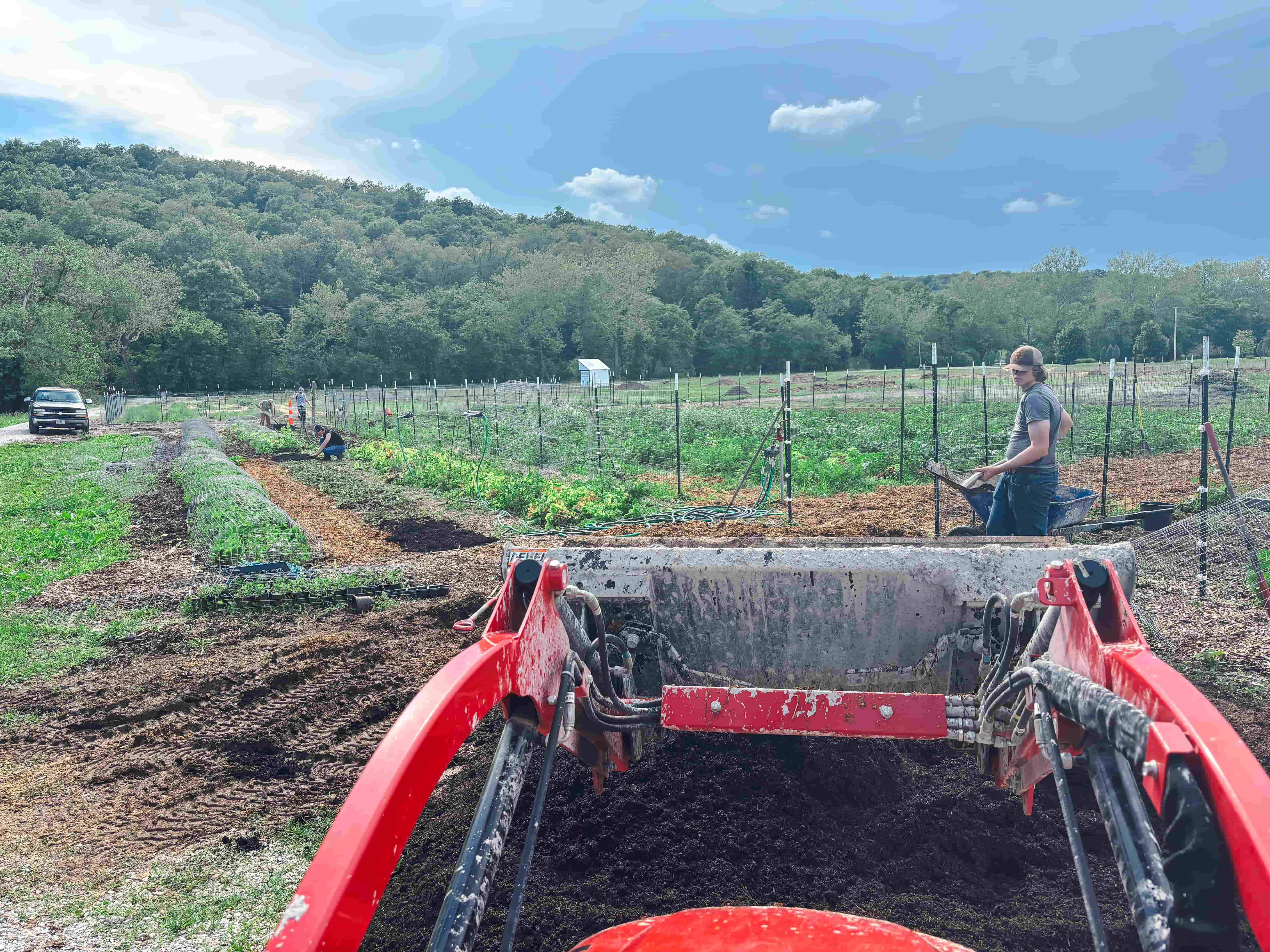 A farm landscape viewed from the back of a truck.